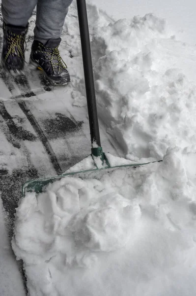 吹雪だ 雪のシャベルを持つ男は冬に歩道をきれいにする 仕事以外の冬の時間 高品質の写真 — ストック写真