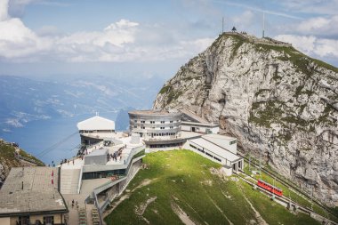 Pilatus Dağı 'nın tepesinde güneşli bir manzara, Lucerne Gölü' ne bakan, çarklı bir tren geliyor, İsviçre