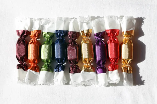 Traditional hungarian christmas sweetness named szaloncukor aka parlour candy in various bright wrapping on white background. Decorations for christmas tree