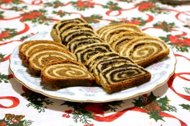 Ev yapımı haşhaş tohumu ya da cevizli kek diğer adıyla beigli ya da bejgli tabakta kanatlı bir melek gibi dilimler. Geleneksel Macar Noel 'i dilimlenmiş kekler masada.