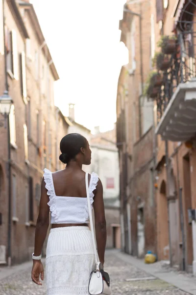 Portrait of African American woman dressed in white getting to know Europe, Ferrara. Italy. High quality photo