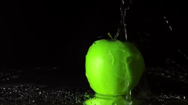 スローモーション水はスプラッシュでリンゴに落ちます 黒を背景に — ストック動画