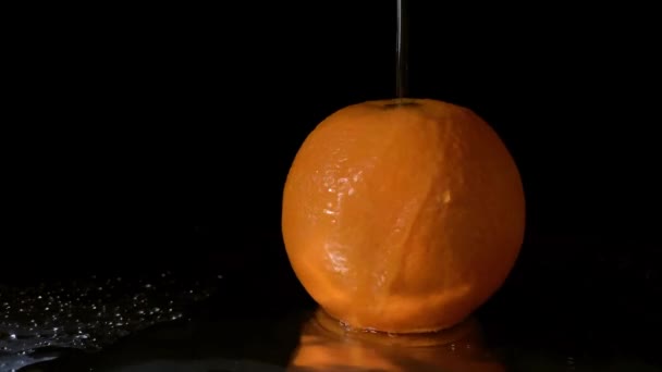 Zeitlupe Ein Schuss Wasser Fällt Auf Orangefarbene Früchte Auf Schwarzem — Stockvideo