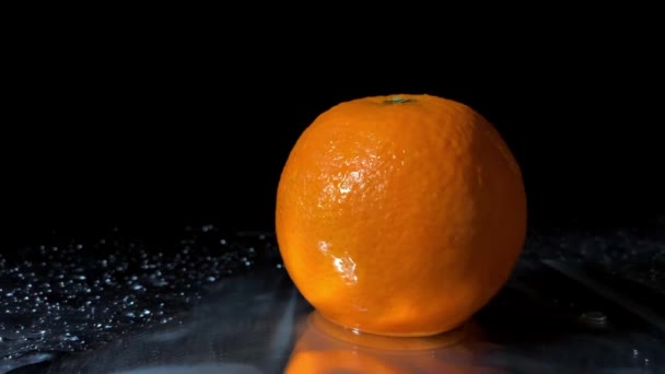 Das Studiotermin Von Wasser Das Auf Orangefarbene Früchte Auf Schwarzem — Stockvideo