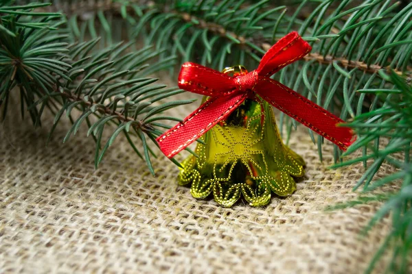 Weihnachtsglockenspielzeug Und Zweig Des Weihnachtsbaums Auf Einem Plattenhintergrund — Stockfoto