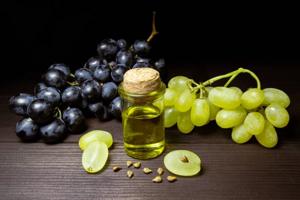 Traubenölkern Einer Kleinen Weinflasche Haufen Traubenkerne Mit Grünen Trauben Und Stockbild