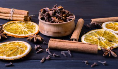 Kurutulmuş portakal dilimi, tarçın çubukları ve ahşap arka planda anason. Geleneksel Noel kompozisyonu