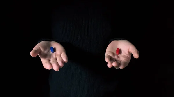 Rote Und Blaue Pillen Auf Händen Isoliert Auf Schwarzem Hintergrund Stockbild