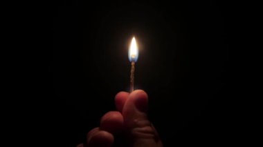 Karanlıkta ellerde ağır çekimde yanan kibrit. Zifiri karanlıkta erkek el ele tutuşma kibriti.