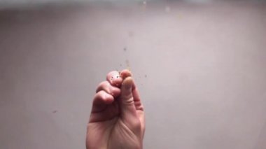 Close-up of the chef's hand adding spice to the dish. Bottom view. Slow motion HD
