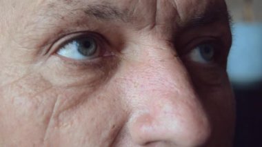 Olgun insanın yüzü ve gözleri. Son sınıf öğrencisinin yüzünde büyük kırışıklıklar var. Çekici yaşlı bir adamın portresi.