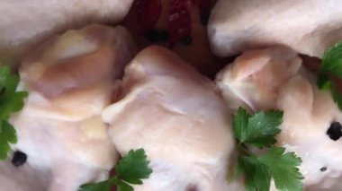 Tahtada taze çiğ tavuk kanatları ve malzemeler. Döndürme hareketi. Beyaz tahta arkaplan