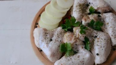 Tavuk kanatları baharatlı ve maydanozlu. Pişirmeye hazırlanıyor.