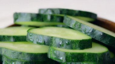 Olgun yeşil dilimlenmiş salatalık rotasyonu. Yiyecek olarak taze salatalık çemberleri. Düzgün beslenme ya da sağlıklı yaşam tarzı ve diyet kavramı. Makro çekim.