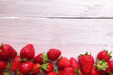 Beyaz ahşap arka planda çilekler, üst manzara, yakın plan. Metin için boşluk