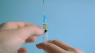 Doktor şırıngayı enjekte etmek için önceden doldurulmuş antibiyotikle şırıngayı hazırlar ve şırıngadan birkaç damla atar..