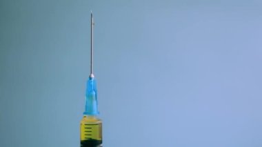 Şırıngada Mavi Arkaplan 'a Karşı Sarı Sıvı Varlığını Kapat. İlaç İğnesi Şırıngası, Grip aşısı Viyal Toz Enjeksiyonu Tedavi Hastalığı Bağışıklık Sistemi.
