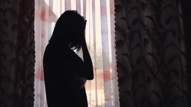 窗前一位忧郁的年轻女子的侧影 — 图库视频影像