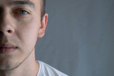 Mavi gözlü, yarım yüzlü, güzel bir gencin portresi.