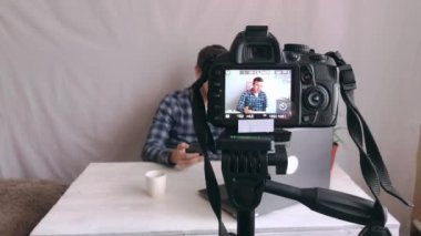 Genç bir blogcu, stüdyosunda kendi kamerasıyla bir video kaydediyor.