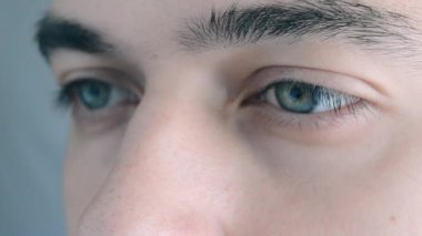 Man 'in yüzüne yakın çekim. Çekici çocuk güzel mavi gözlerini aç. Beyaz erkek model, mavi gözlü, makro yakın plan.