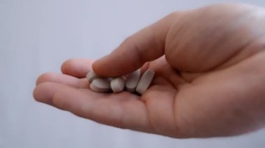 El ele tutuşan bir yığın hap. Tıbbi ilaçlar ve ilaç kavramı