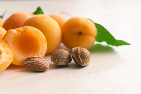 Aprikosen Und Kerne Auf Weißem Holzgrund Aprikosensamen Stockbild