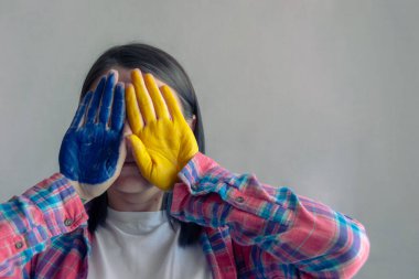 Genç kadın elini mavi sarı Ukrayna bayrağı renklerine boyadı. Boşluğu Kopyala