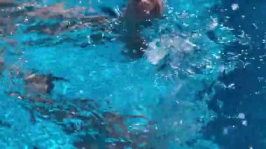 Sıska kadının bacakları havuza su sıçratıyor. Dinlenme, tatil konsepti