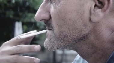 Caucasian middle aged man smoking a cigarette. Black and white HD footage