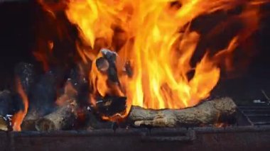 fire burns in a brazier with firewood. Kindling the grill for cooking meat. Close up. Background