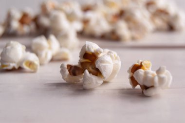 Popcorn on a white wooden table, close up