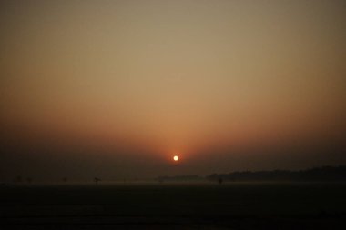 Hindistan kırsalında gün doğumu sisli bir manzarayla