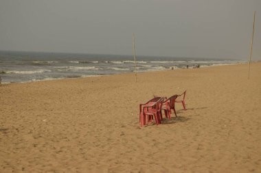 Puri Sea Beach, Odisha, Hindistan - 16 Mart 2022: Deniz sahilinde oturmak için izole sandalyeler