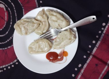 Tavuk Momo 'lar sosis ve çatalla servis edilir.