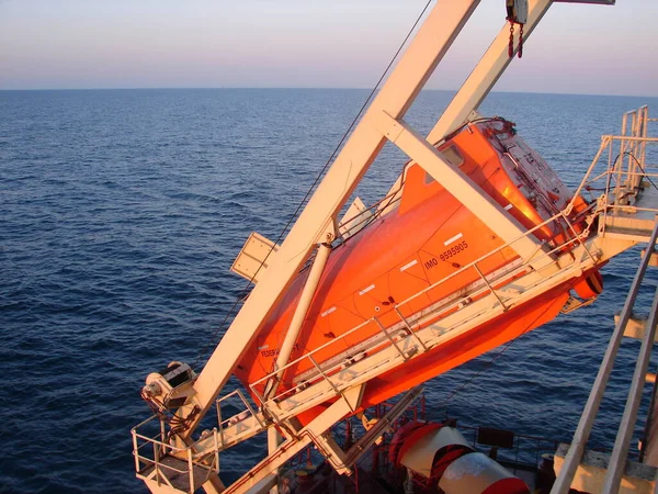 Tamamen kapalı bir cankurtaran botu bir gemiyle beşiğe yerleştirilmiş.