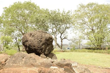 Çürümüş yuvarlak kaya mahakali ya da kondivit mağara binalarındaki taşlı yüzeyde dengelenmiş.