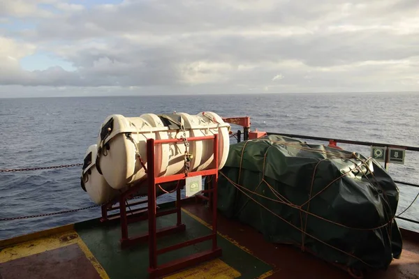 life rafts stowed on the cradles of a ship