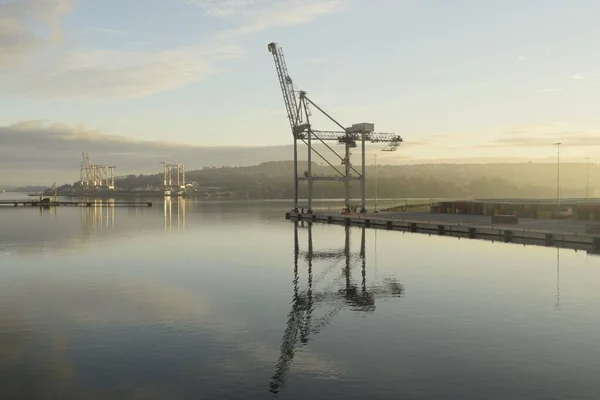 isolated gantry crane in container terminal of the ringaskiggy harbor in the early morning light