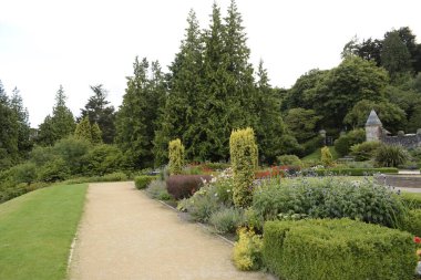 belfast castle, cavehill country park, belfast, northern ireland, united kingdom - august 8, 2022 : pathway through decorated garden with abundant greenery 