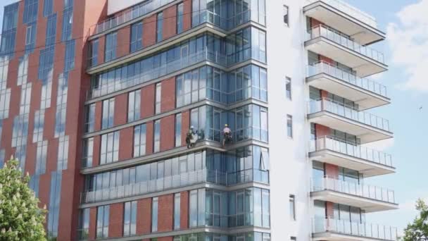 Fensterfassade Glasreiniger klettert auf Scheibenwaschanlage an Bürohochhaus — Stockvideo