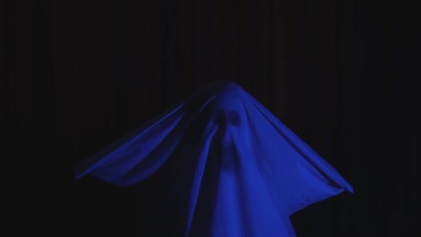 Halloween festa fantasia fantasma folha com rosto assustador escuro fundo luz azul — Vídeo de Stock