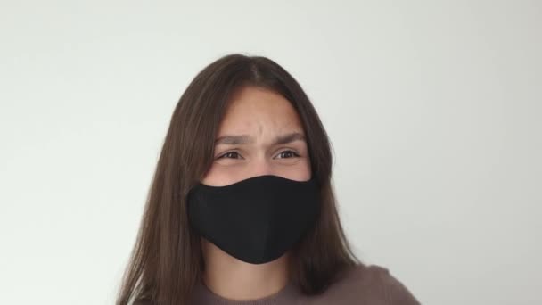 Portrait jeune brunette femelle en noir masque médical de protection agressif scold — Video