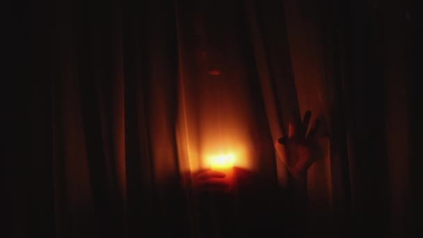 Eng griezelig vrouw silhouet met brandende kaars bewegen achter gordijn in het donker — Stockvideo