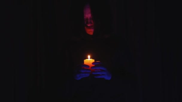 Przerażające przerażające kobieta sylwetka z płonące świece porusza się w kierunku kamery w ciemności — Wideo stockowe