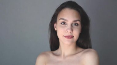 Güzel esmer, genç bayan, beyaz, çıplak öğrenci omuzları. Kameraya bak. 