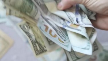 El sıkışıyor, buruşmuş Amerikan dolarları sallanıyor.