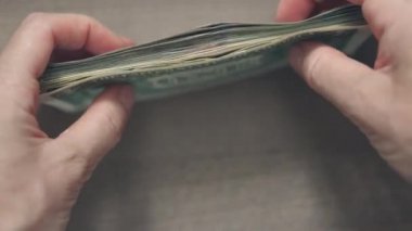 El ele tutuşup katlanır deste deste deste Amerikan doları banknotları.