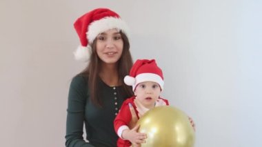 Mutlu Kafkas Noel ailesi annesi yeşil gömlek bebek Noel Baba kırmızı şapka balonu
