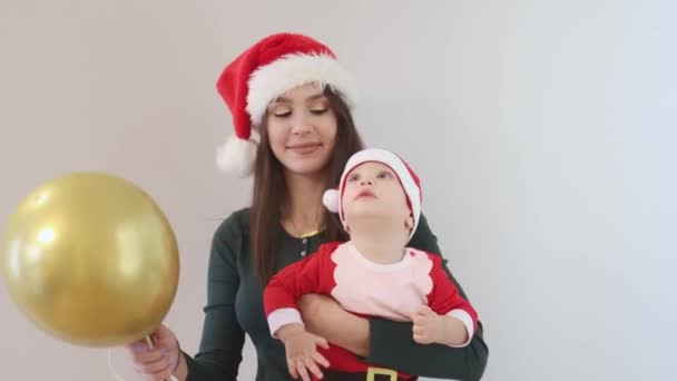 Gelukkig Kaukasisch Kerstmis familie moeder groen shirt baby Santa rood hoed ballon — Stockvideo